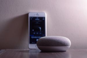 Image of Gray Google Home Mini Beside Silver Iphone 5s
